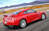 Nissan GT-R. Modelo 2008. Imagen. Exterior. Posterior lateral. Coche en movimiento. Carretera. Color Vibrant Red.