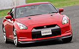 Nissan GT-R. Modelo 2008. Imagen. Exterior. Frontal. Coche en movimiento. Carretera. Color Vibrant Red.