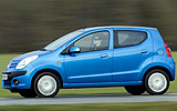 Nissan Pixo. Modelo 2009. Imagen. Exterior. Lateral. Coche en movimiento. Carretera. Azul.