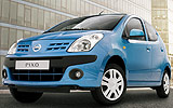 Nissan Pixo. Modelo 2009. Imagen. Exterior. Frontal lateral. Coche parado. Carretera. Azul.