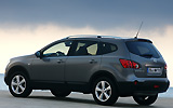 Nissan Qashqai+2. Modelo 2009. Imagen. Lateral- posterior. Coche parado. Carretera. Gris.