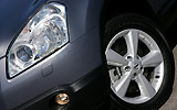 Nissan Qashqai+2. Modelo 2009. Imagen. Detalle faro izquierdo. Llanta. Gris.