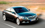 Opel Insignia. Modelo 2009. Carrocer�a 4 puertas. Imagen. Exterior. Lateral frontal. Coche en movimiento. Carretera. Gris oscuro.