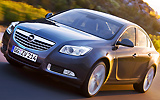Opel Insignia. Modelo 2009. Carrocer�a 4 puertas. Imagen. Exterior. Frontal lateral. Coche en movimiento. Carretera. Gris oscuro.