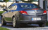Opel Insignia. Modelo 2009. Carrocer&iacute;a 4 puertas. Imagen. Exterior. Lateral posterior. Coche parado. Carretera. Gris oscuro.