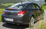 Opel Insignia. Modelo 2009. Carrocer&iacute;a 4 puertas. Imagen. Exterior. Posterior lateral. Coche en movimiento. Carretera. Gris oscuro.
