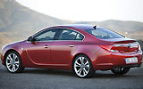 Opel Insignia. Modelo 2009. Carrocer&iacute;a 4 puertas. Imagen. Exterior. Lateral posterior. Coche parado. Carretera. Rojo.