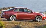 Opel Insignia. Modelo 2009. Carrocer&iacute;a 4 puertas. Imagen. Exterior. Lateral. Coche en movimiento. Carretera. Rojo.