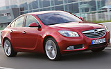 Opel Insignia. Modelo 2009. Carrocer�a 4 puertas. Imagen. Exterior. Lateral frontal. Coche en movimiento. Carretera. Rojo.