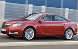 Opel Insignia. Modelo 2009. Carrocer�a 4 puertas. Imagen. Exterior. Lateral. Coche en movimiento. Carretera. Rojo.