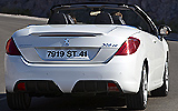 Peugeot 308 CC. Modelo 2009. Imagen. Exterior. Posterior lateral. Coche en movimiento. Carretera. Descapotado. Blanco brillante.