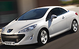 Peugeot 308 CC. Modelo 2009. Imagen. Exterior. Frontal lateral. Coche en movimiento. Carretera. Techo r�gido plegable. Blanco brillante.