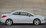 Peugeot 308 CC. Modelo 2009. Imagen. Exterior. Lateral. Coche parado. Carretera. Techo r�gido plegable. Blanco brillante.