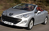 Peugeot 308 CC. Modelo 2009. Imagen. Exterior. Frontal lateral. Coche en movimiento. Carretera. Descapotado. Gris aluminio.