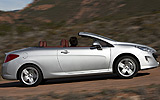 Peugeot 308 CC. Modelo 2009. Imagen. Exterior. Lateral. Coche en movimiento. Carretera. Descapotado. Gris aluminio.