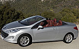 Peugeot 308 CC. Modelo 2009. Imagen. Exterior. Frontal lateral cenital. Coche parado. Carretera. Descapotado. Gris aluminio.