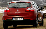 Renault Megane. Modelo 2009. Imagen. 5 puertas. Lateral posterior. Coche en movimiento. Carretera. Rojo.