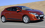 Renault M�gane Coup�. Modelo 2009. Imagen exterior. Tres puertas. Lateral frontal. Movimiento. Carretera. Naranja.