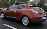 Renault M�gane Coup�. Modelo 2009. Imagen exterior. Tres puertas. Lateral posterior. Movimiento. Carretera. Naranja.