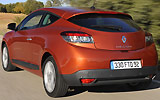 Renault M�gane Coup�. Modelo 2009. Imagen exterior. Tres puertas. Lateral posterior. Movimiento. Carretera. Naranja.