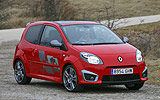Renault Twingo RS. Modelo 2009. Imagen. Lateral frontal. Coche en movimiento. Carretera. Rojo.