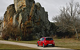 Renault Twingo RS. Modelo 2009. Imagen. Lateral posterior. Parado. Carretera con paisaje. Rojo.