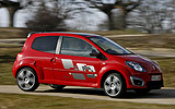 Renault Twingo RS. Modelo 2009. Imagen. Lateral frontal. Movimiento. Coche en carretera. Rojo.