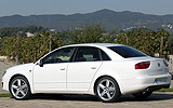 SEAT Exeo. Modelo 2009. Imagen exterior. Lateral posterior. Coche parado. Carretera. Blanco.