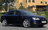 SEAT Exeo. Modelo 2009. Imagen exterior. Lateral frontal. Coche parado. Carretera. Azul.