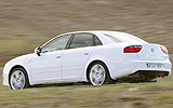SEAT Exeo. Modelo 2009. Imagen exterior. Lateral posterior. Coche en movimiento. Carretera. Blanco.