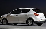 SEAT Ibiza ECOMOTIVE. Modelo 2009. Imagen. Exterior. Lateral. Coche parado. Carretera. Faros y pilotos en on. Blanco.