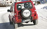 Suzuki Jimny. Modelo 2008. Imagen exterior. Lateral posterior. Coche en movimiento. Carretera. Rojo.