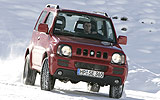 Suzuki Jimny. Modelo 2008. Imagen exterior. Lateral frontal. Coche parado. Carretera con nieve. Rojo.