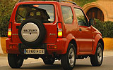 Suzuki Jimny. Modelo 2008. Imagen exterior. Posterior lateral. Coche parado. Carretera. Rojo.