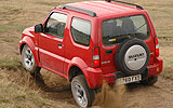 Suzuki Jimny. Modelo 2008. Imagen exterior. Lateral posterior. Movimiento. Campo. Rojo.