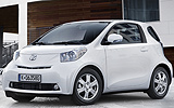 Toyota iQ. Modelo 2009. Imagen. Frontal lateral. Coche parado. Carretera. Blanco.