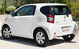 Toyota iQ. Modelo 2009. Imagen. Lateral posterior. Coche parado. Carretera. Blanco.