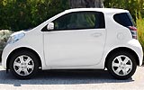 Toyota iQ. Modelo 2009. Imagen. Lateral. Coche parado en carretera. Blanco.
