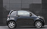 Toyota iQ. Modelo 2009. Imagen. Lateral. Coche parado. Carretera. Negro.