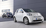 Toyota iQ. Modelo 2009. Imagen. Lateral. Coche parado. Carretera. Blanco. Negro.