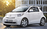 Toyota iQ. Modelo 2009. Imagen. Frontal lateral. Coche parado. Carretera. Blanco.