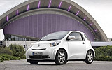 Toyota iQ. Modelo 2009. Imagen. Frontal lateral. Parado. Coche en carretera. Blanco.