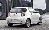 Toyota iQ. Modelo 2009. Imagen. Posterior lateral. Coche parado. Carretera. Blanco.