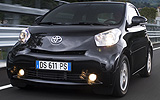 Toyota iQ. Modelo 2009. Imagen exterior. Frontal. Movimiento. Carretera. Negro.