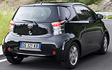 Toyota iQ. Modelo 2009. Imagen exterior. Posterior lateral. Movimiento. Carretera. Negro.
