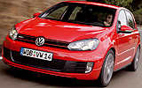 Volkswagen Golf GTI. Modelo 2009. 5 puertas. Imagen. Exterior. Frontal lateral. Coche en movimiento. Carretera. Faros encendidos. Rojo.