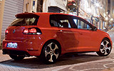 Volkswagen Golf GTI. Modelo 2009. 5 puertas. Imagen. Exterior. Posterior lateral. Coche parado. Carretera. Llantas de aleaci�n ligera de 18 pulgadas �Detroit�. Pilotos encendidos. Rojo.