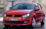 Volkswagen Polo. Modelo 2009. Imagen. Exterior. Frontal. Coche en movimiento. Carretera. Luces faros en on. Rojo.