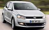 Volkswagen Polo. Modelo 2009. Imagen. Exterior. Lateral frontal. Coche en movimiento. Carretera. Luces faros encendidos. Gris.