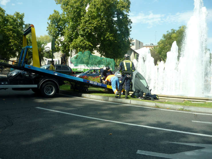 Los hombres de la grúa sacan el smart de la fuente.